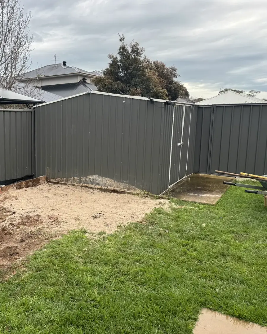 After: Cubby and sandpit removed, leaving a level patch of soil beside the lawn