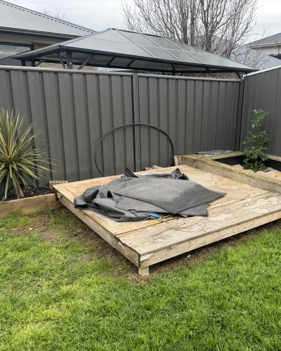 Before: Timber cubby base and sandpit in a backyard corner