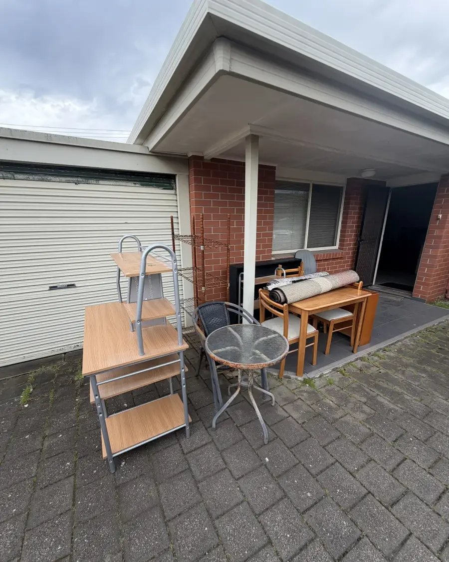 Before: Tables, chairs and shelving in a unit courtyard
