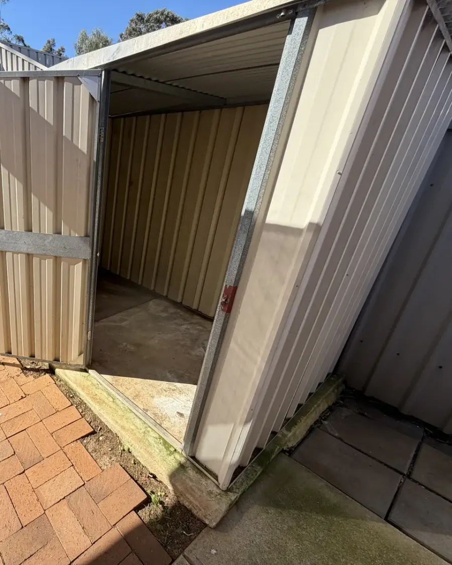 After: Empty, swept-out garden shed with the door open