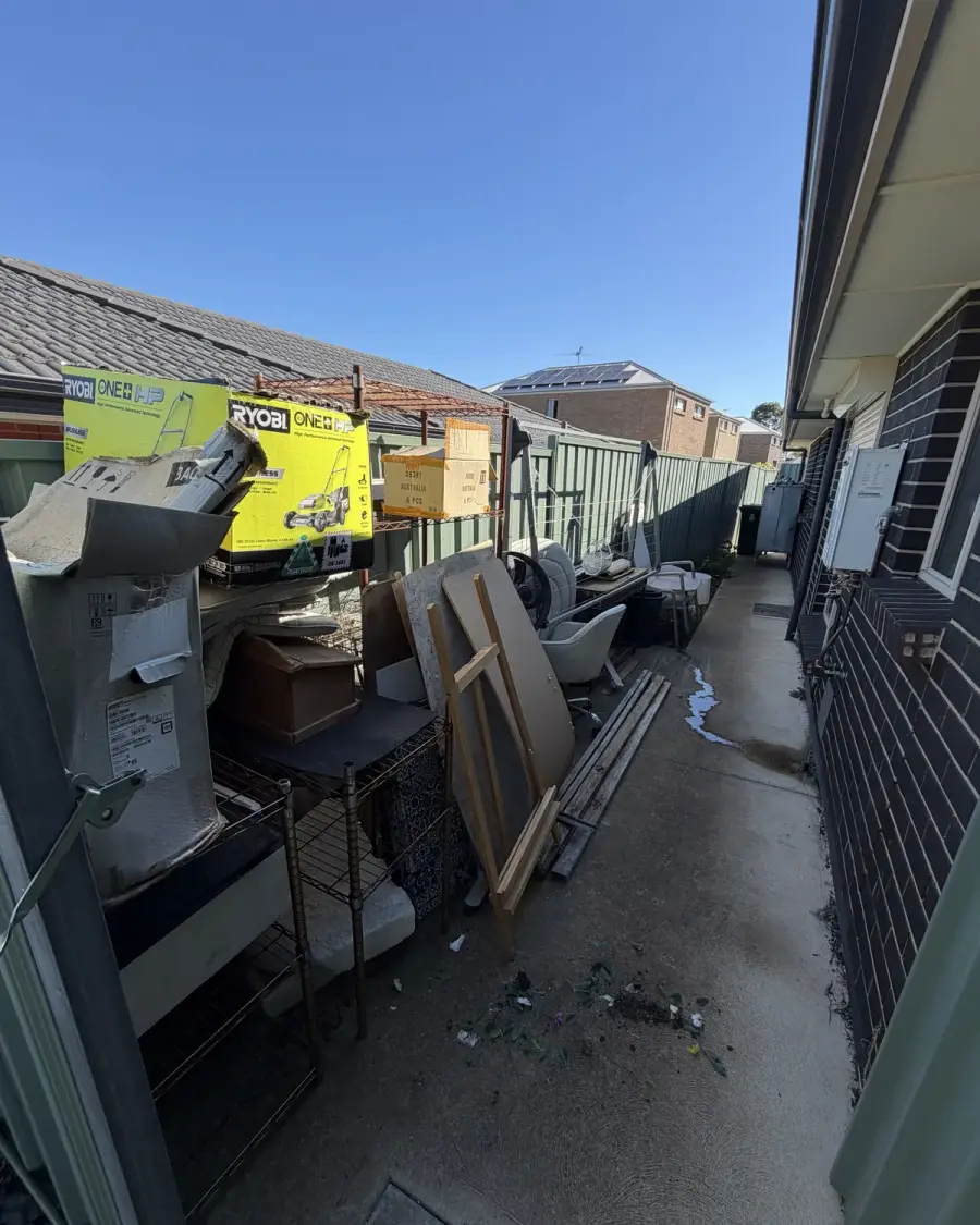 Before: Appliances, timber and boxes crowding a narrow side path
